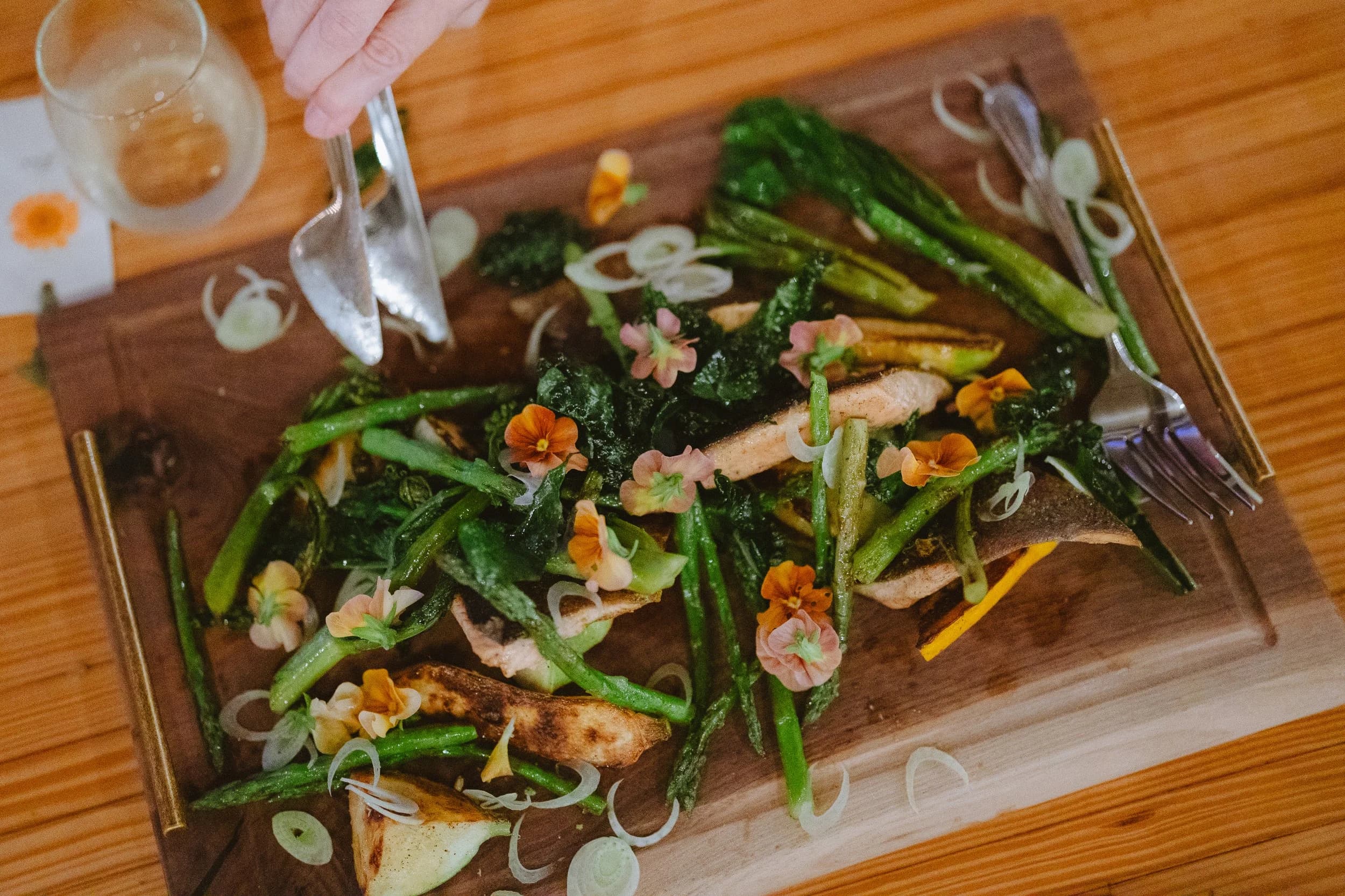 Gourmet fish dish with greens and edible flowers