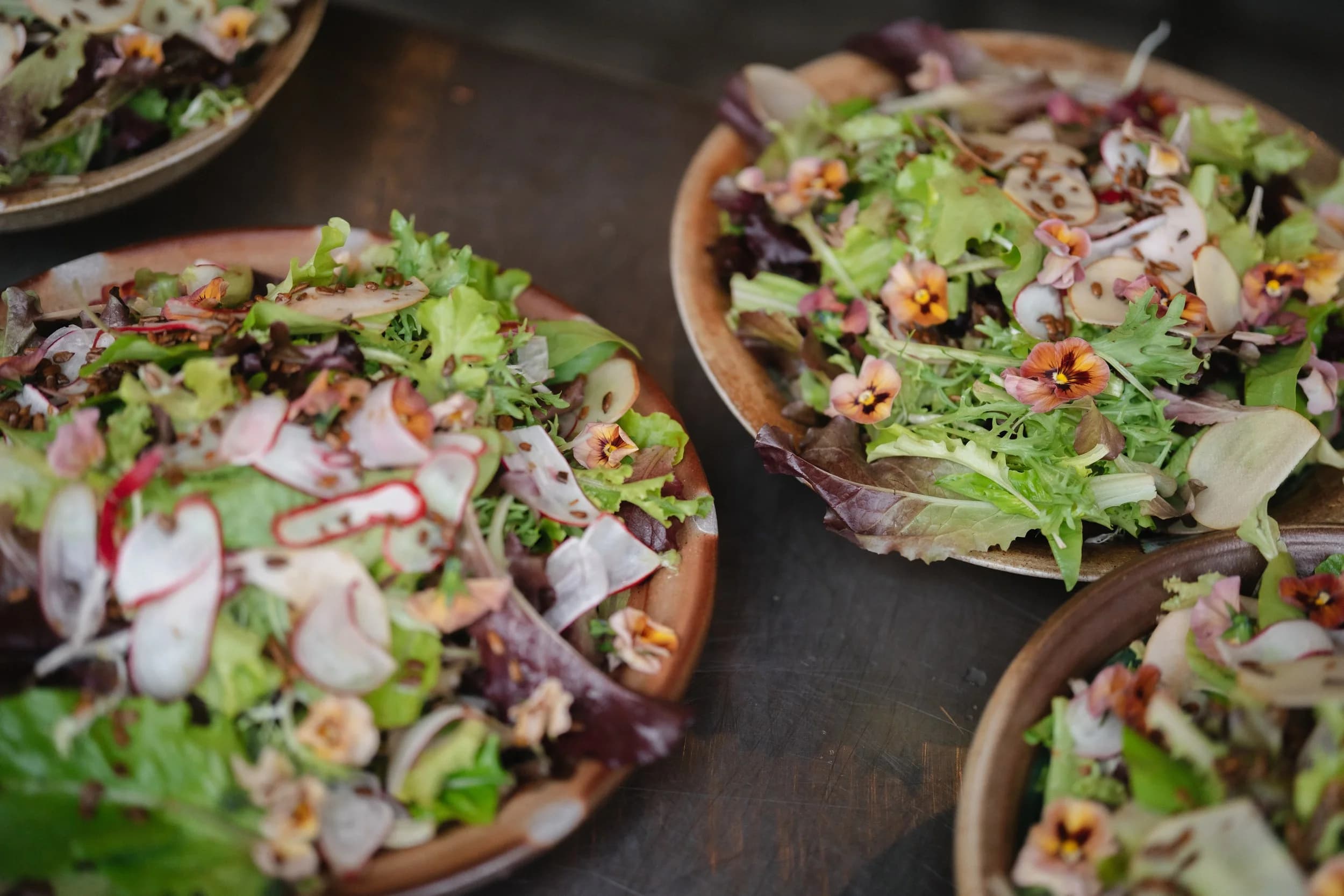 Multiple salad plates with edible flowers